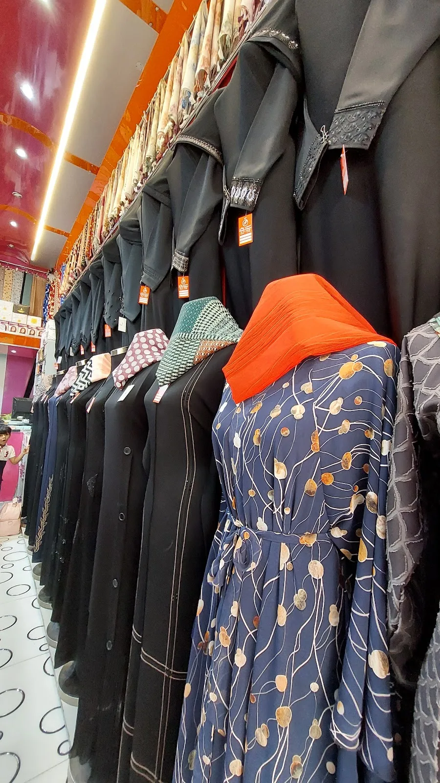 Rows of abayas and gowns on display inside Parda Palace, Deira