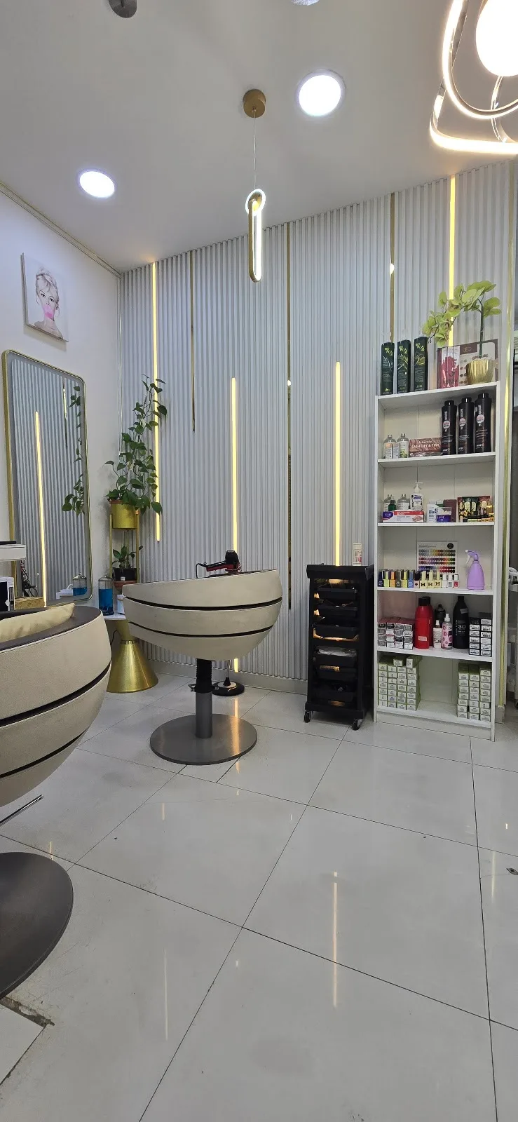 Inside My Wish Ladies Salon — a bright styling station with a fluted backdrop, gold accent lighting and a velvet chair