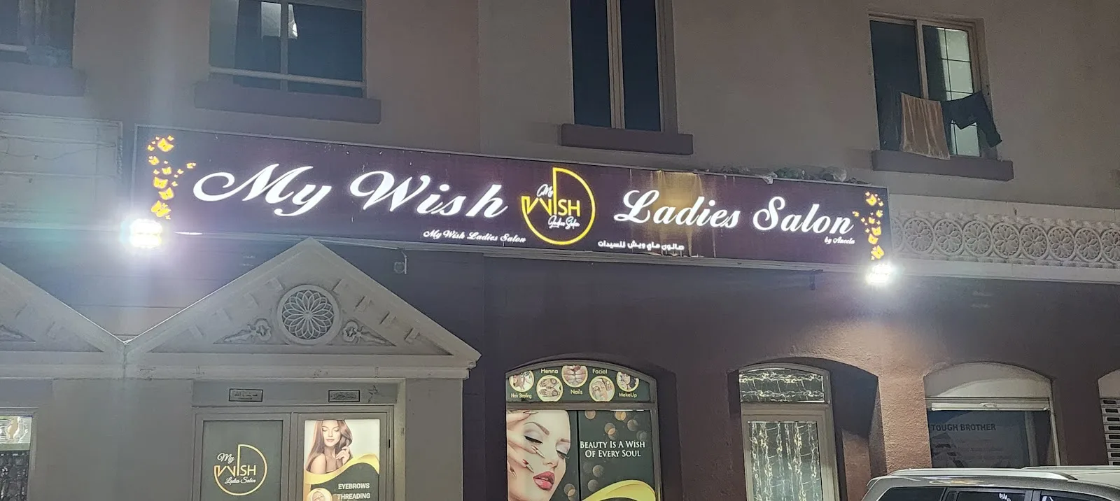 My Wish Ladies Salon sign lit up at night in Warsan First