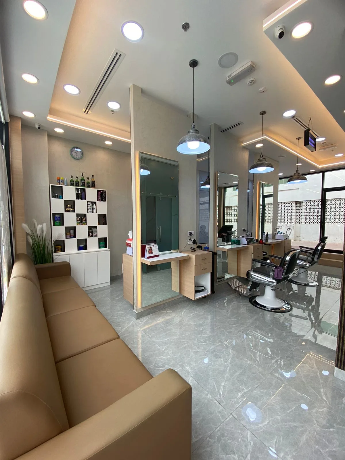 Bright HAIR DRIVE salon interior with leather sofa, mirror stations and barber chairs by the window
