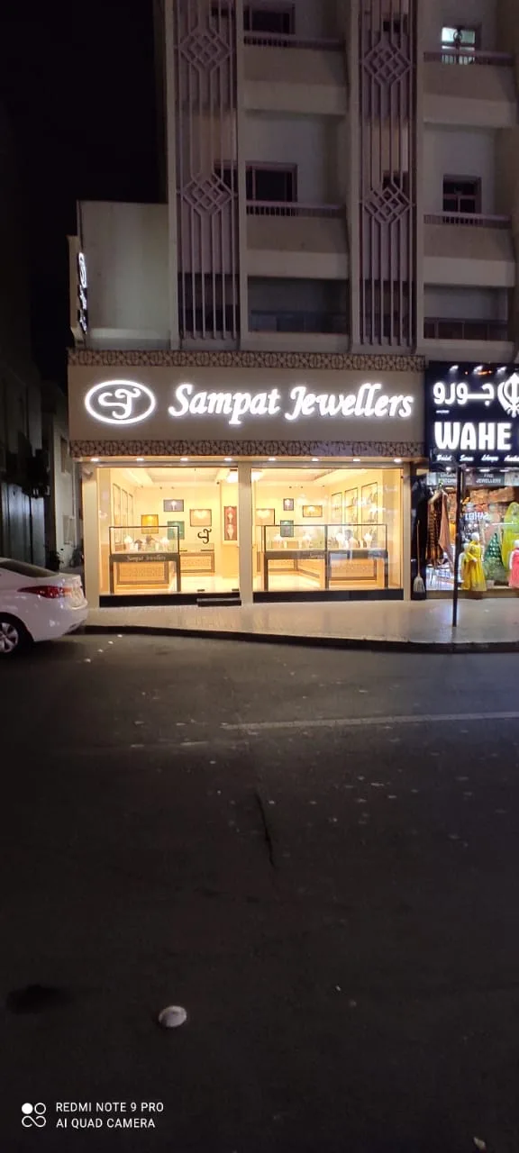 Sampat Jewellers showroom lit up at night with illuminated signage