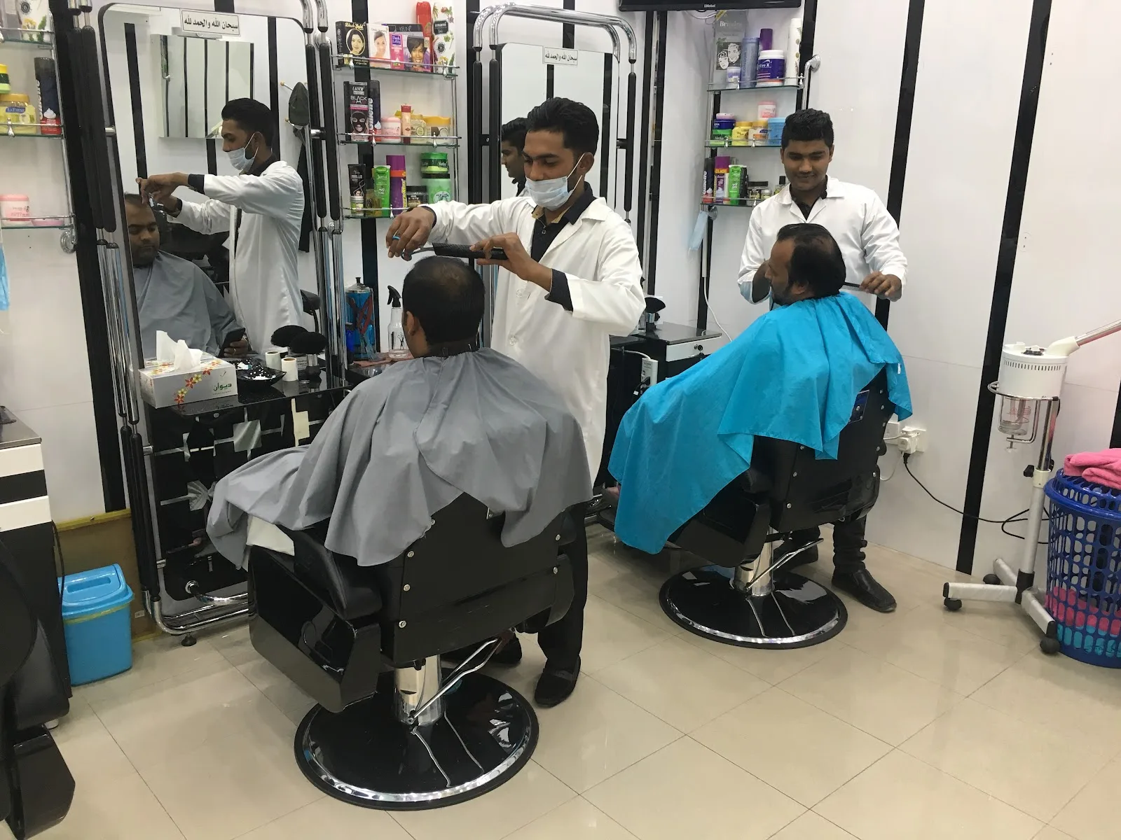 Barbers giving haircuts at Hair House Gents Saloon
