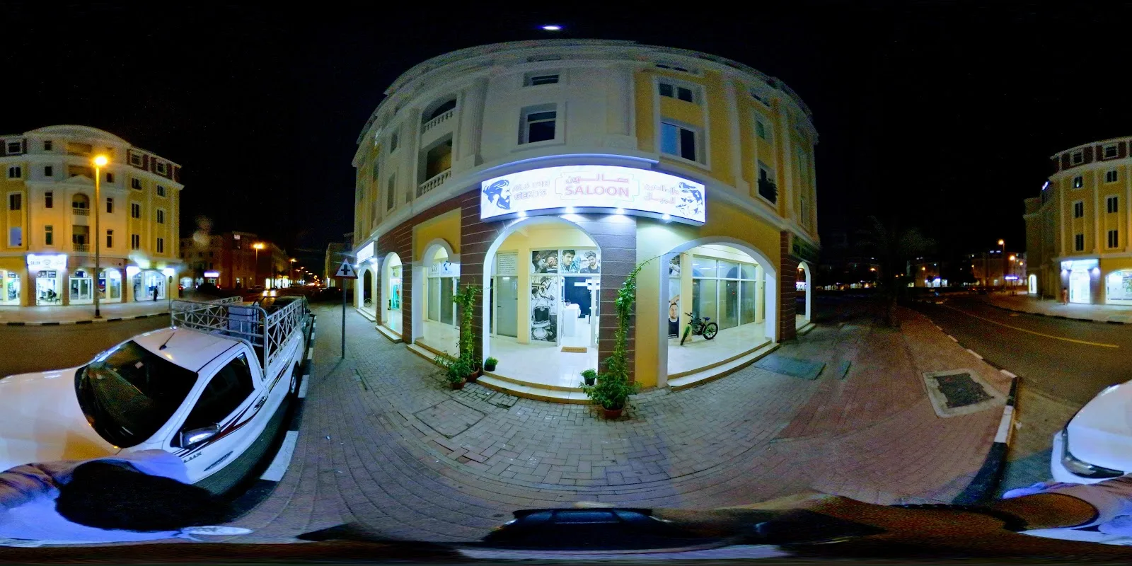 Night view of the corner building housing AlaDin Gents Saloon in International City