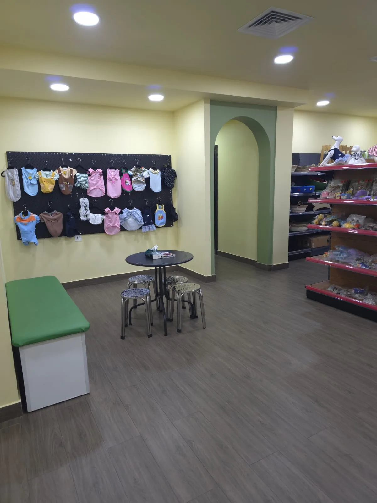 A cosy corner with pet clothing display and seating at Pet Moment