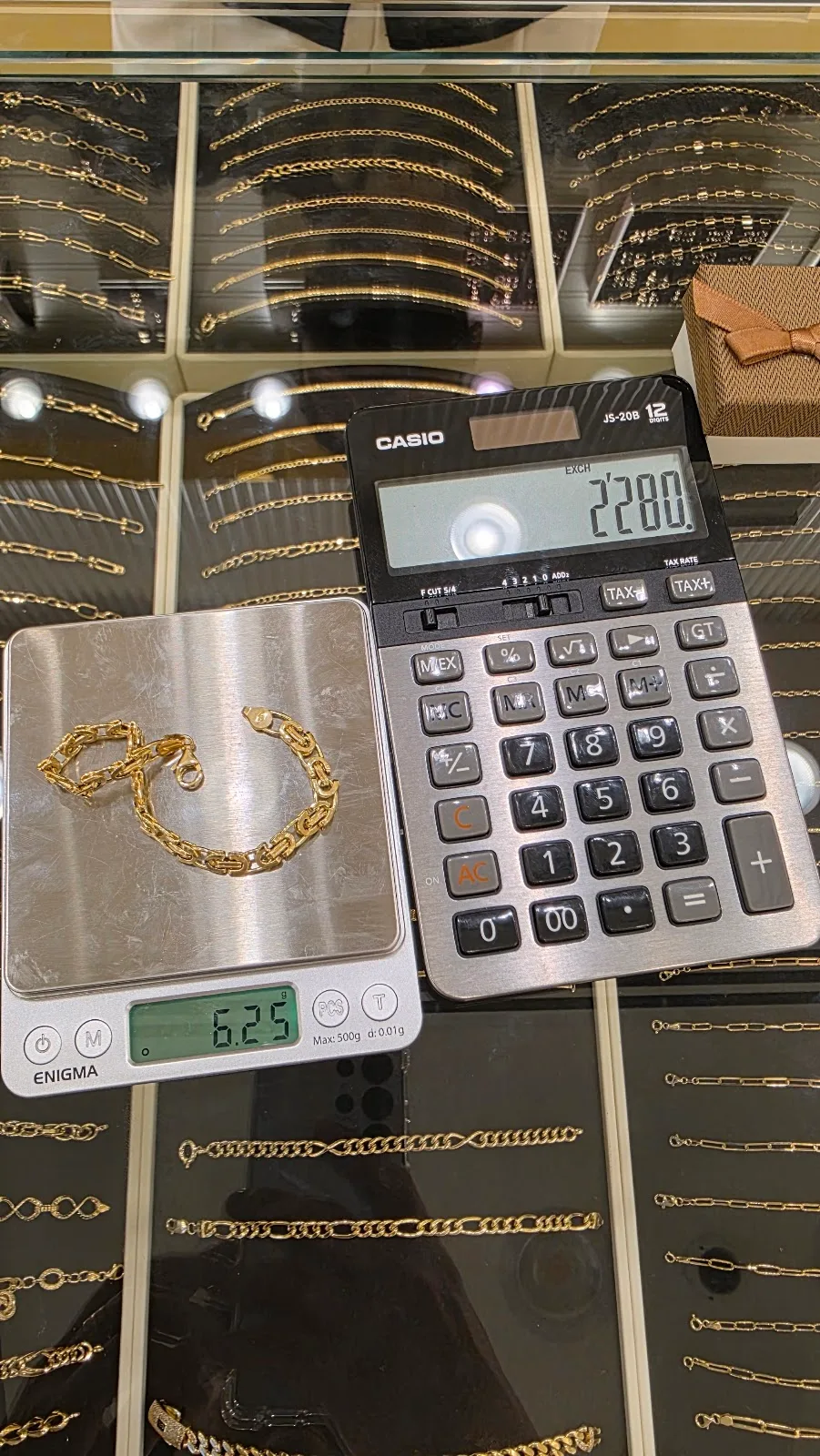 A gold bracelet being weighed on a jeweller's scale