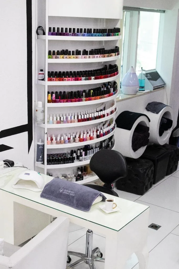 Inside the salon: floor-to-ceiling nail polish colour wall and manicure station