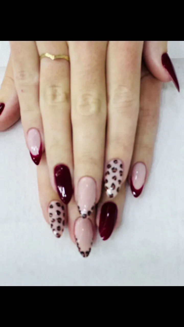 Almond nails in burgundy with leopard-print nail art