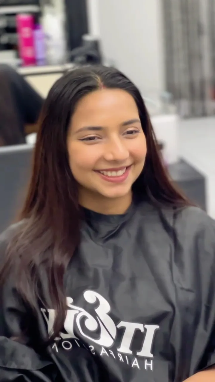 Client smiling after a brunette colour and blow-dry