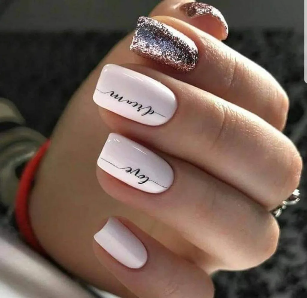 Soft pink square nails with delicate script lettering and a glitter accent
