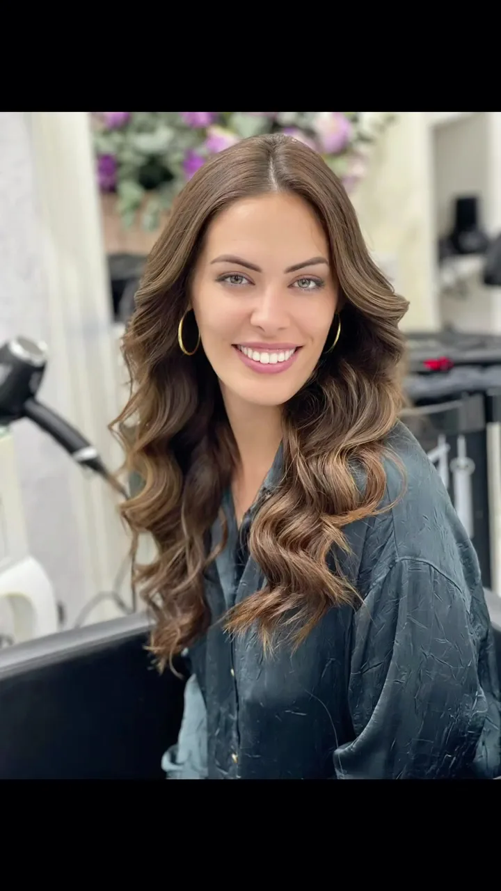 Client with glossy brunette waves and gold hoop earrings after styling