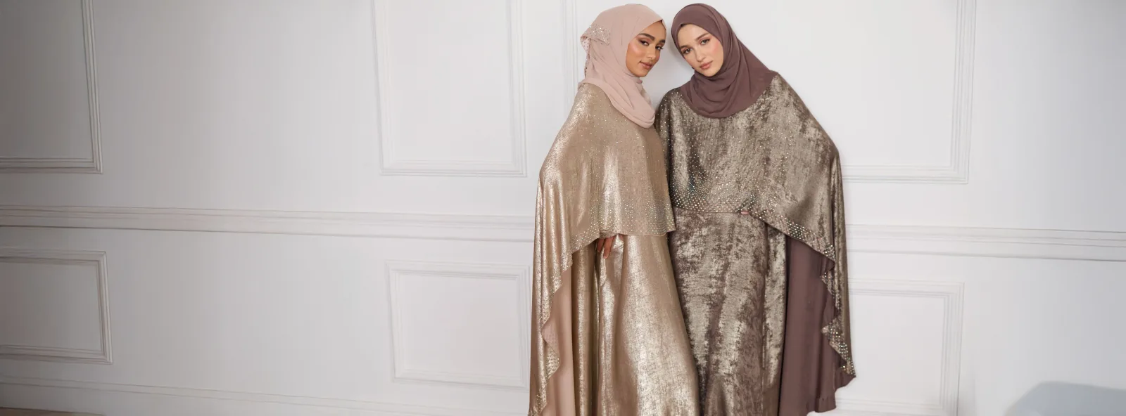 Two models in shimmering gold occasion abayas with matching hijabs at Golden Gate Abaya