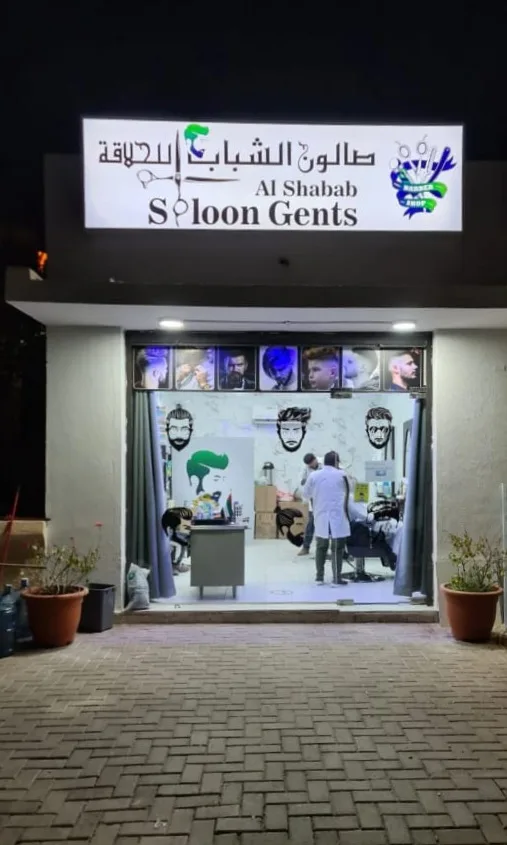 Al Shabab Gents Saloon storefront at night