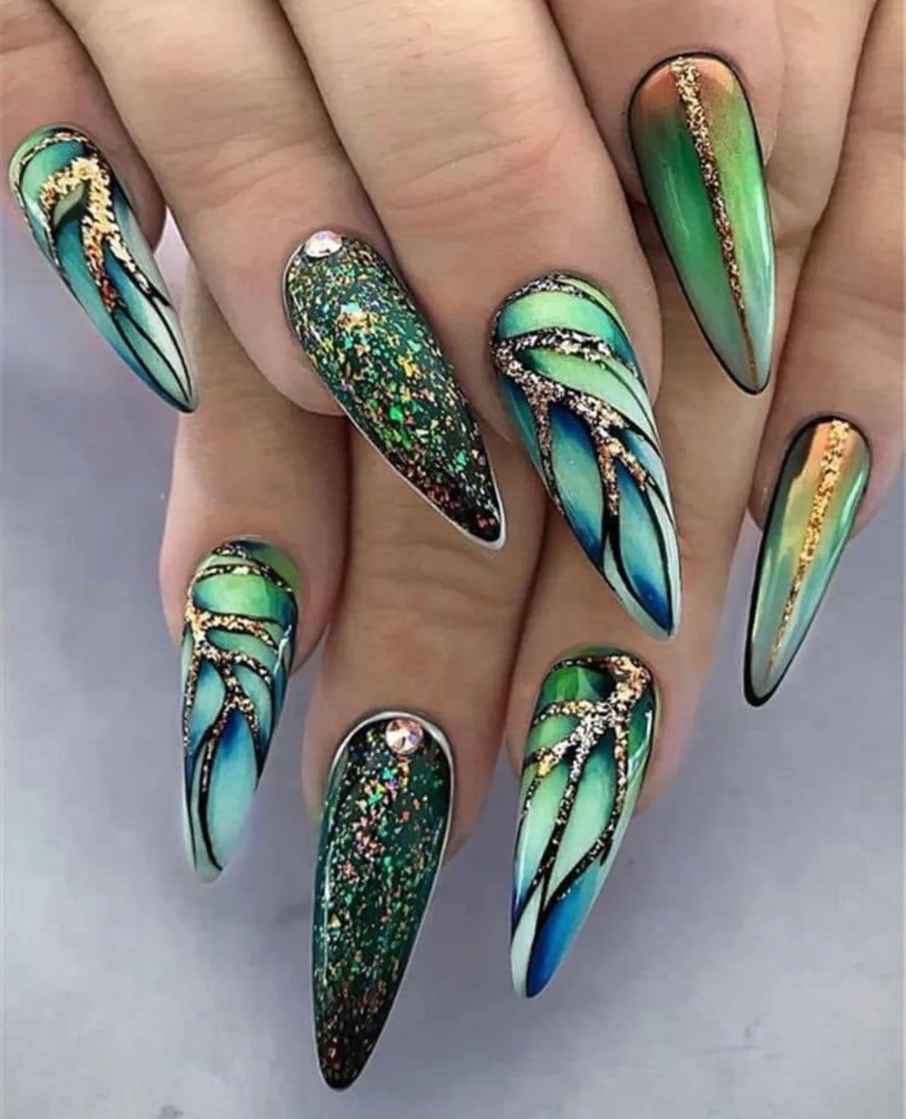 Detailed green and gold nail art with crystals