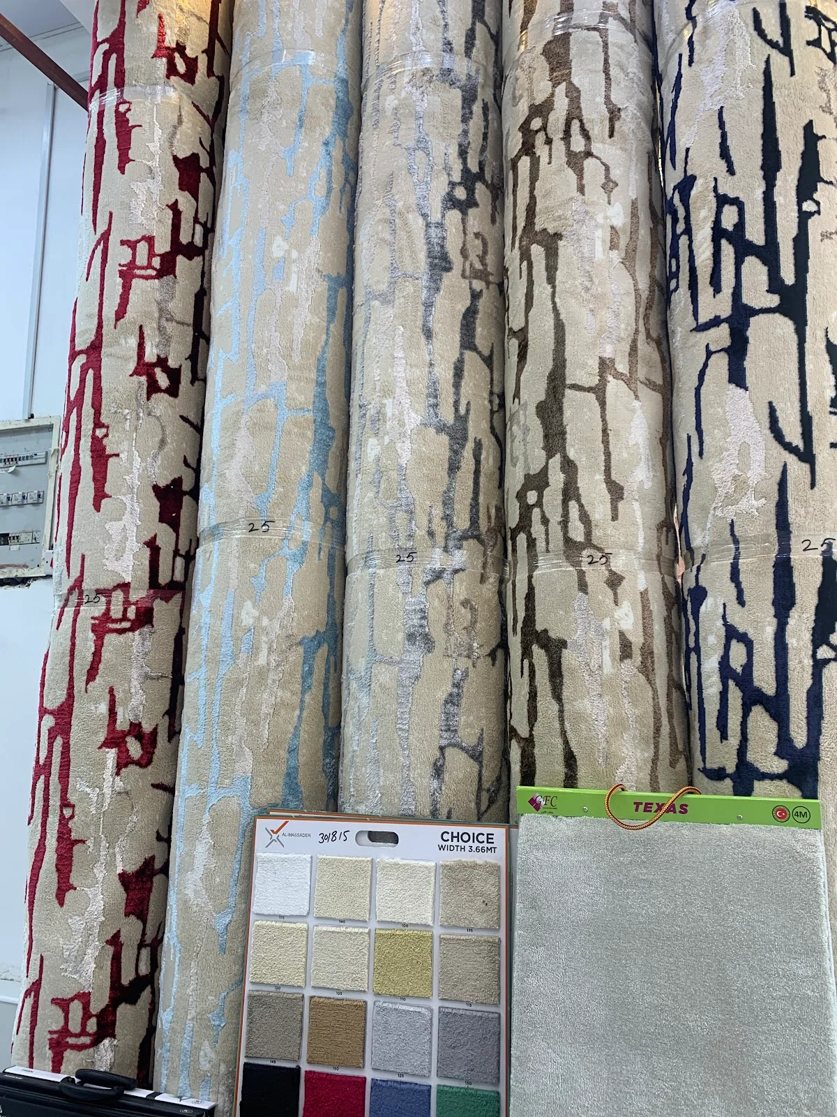 Rolls of patterned carpet and rug samples stacked in the Green Mountain showroom